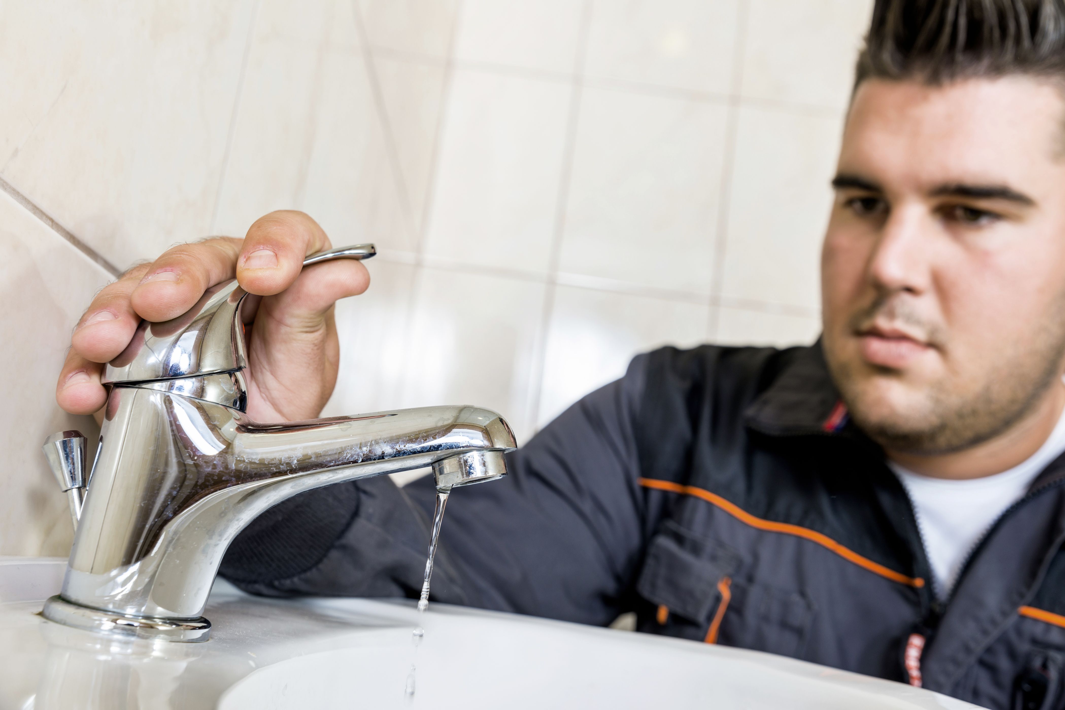 man-fixing-sink-faucet